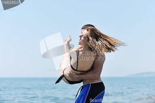 Image of happy young couple have fun on beach