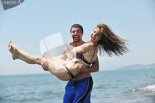 Image of happy young couple have fun on beach