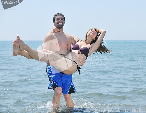 Image of happy young couple have romantic time on beach