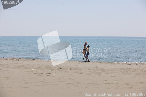 Image of happy young couple have fun on beach