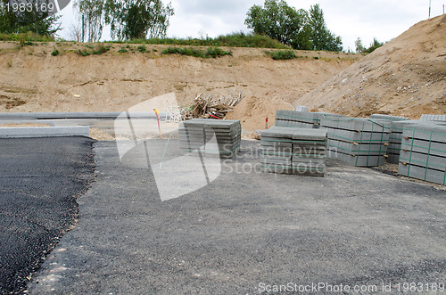 Image of new asphalt road construction site. tiles curbs 