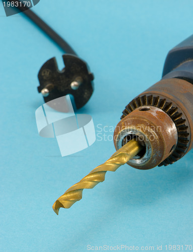 Image of rusty old electric drill golden bit closeup 