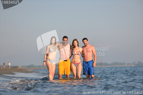 Image of happy people group have fun and running on beach