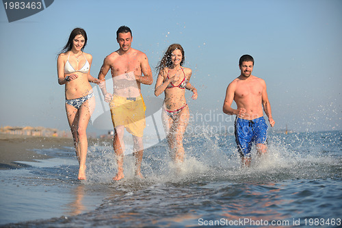 Image of happy people group have fun and running on beach