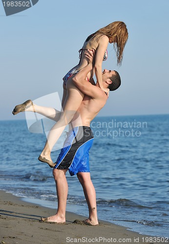 Image of happy young couple have romantic time on beach