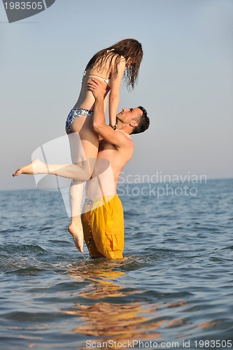 Image of happy young couple have fun on beach
