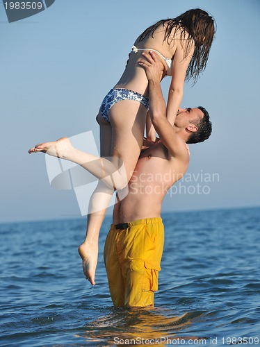 Image of happy young couple have romantic time on beach