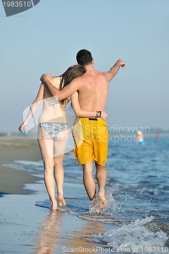 Image of happy young couple have fun on beach