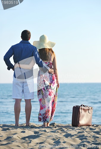 Image of couple on beach with travel bag