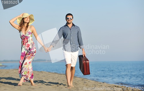 Image of couple on beach with travel bag