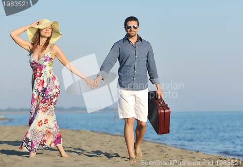 Image of couple on beach with travel bag