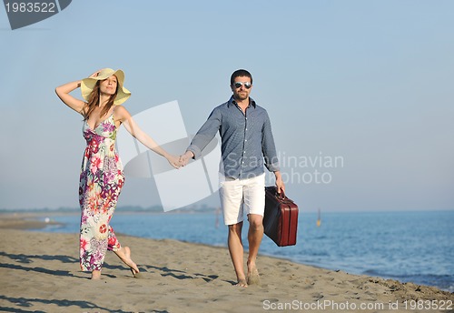 Image of couple on beach with travel bag