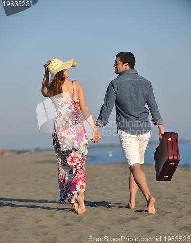 Image of couple on beach with travel bag