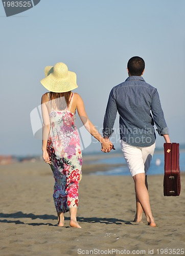 Image of couple on beach with travel bag
