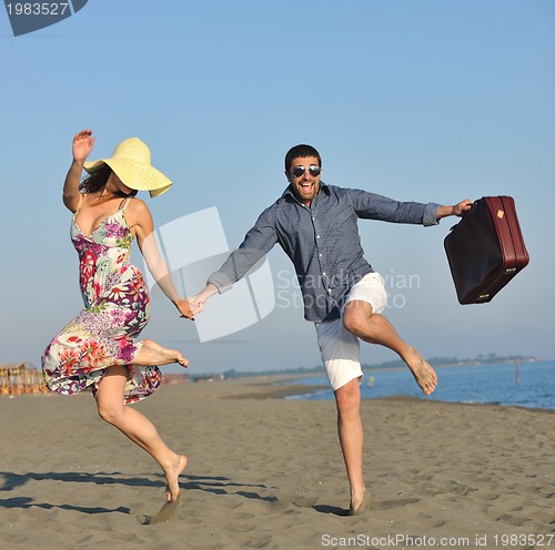 Image of couple on beach with travel bag