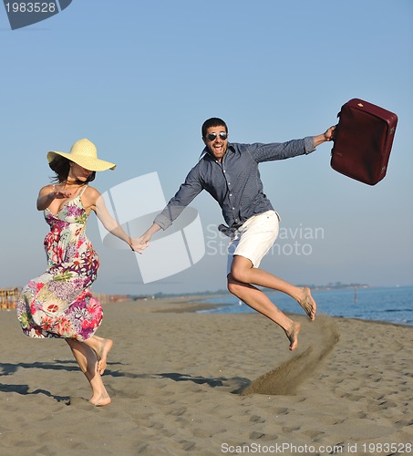 Image of couple on beach with travel bag