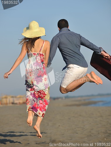 Image of couple on beach with travel bag