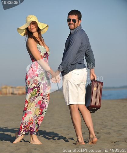 Image of couple on beach with travel bag