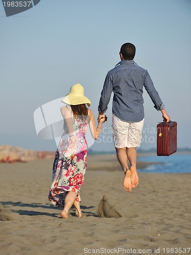 Image of couple on beach with travel bag