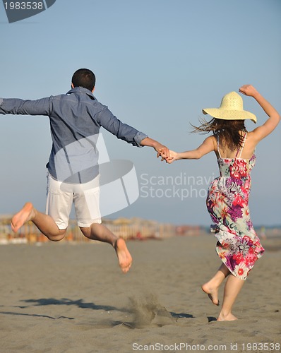 Image of couple on beach with travel bag