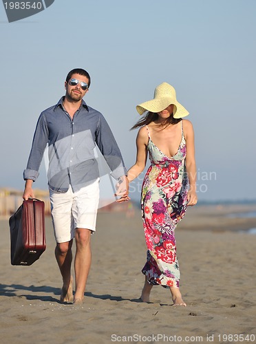 Image of couple on beach with travel bag