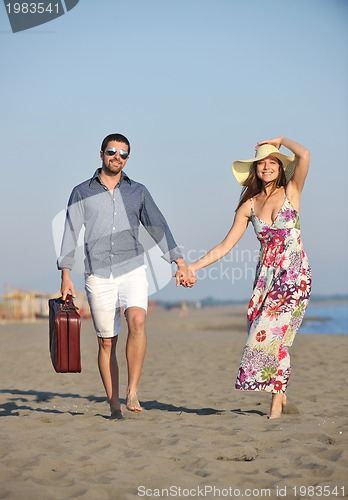Image of couple on beach with travel bag