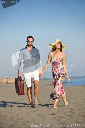 Image of couple on beach with travel bag