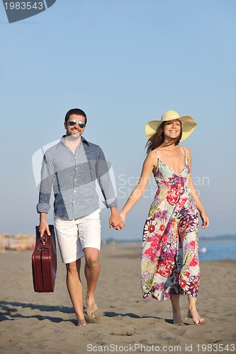 Image of couple on beach with travel bag