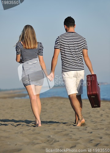 Image of couple on beach with travel bag