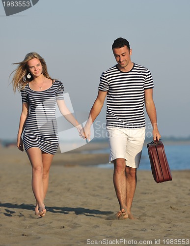 Image of couple on beach with travel bag