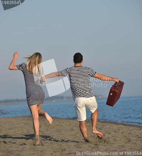 Image of couple on beach with travel bag