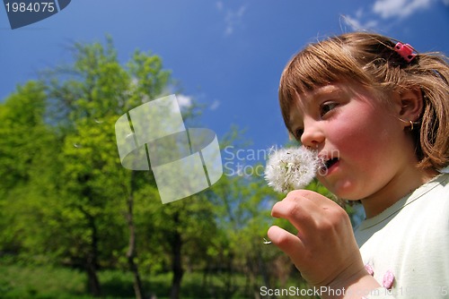 Image of cute girl blowing dundelion