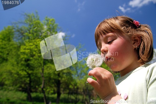 Image of cute girl blowing dundelion