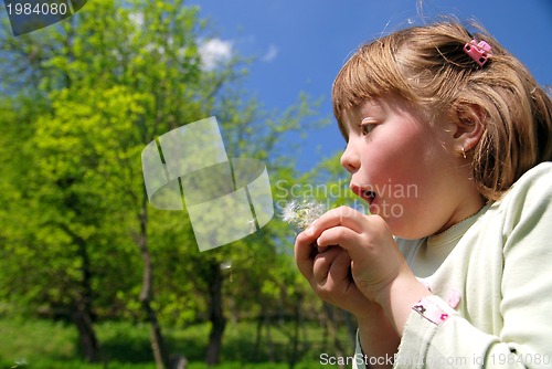 Image of cute girl blowing dundelion