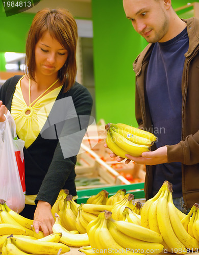 Image of happy couple buying bananas