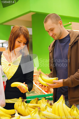 Image of happy couple buying bananas