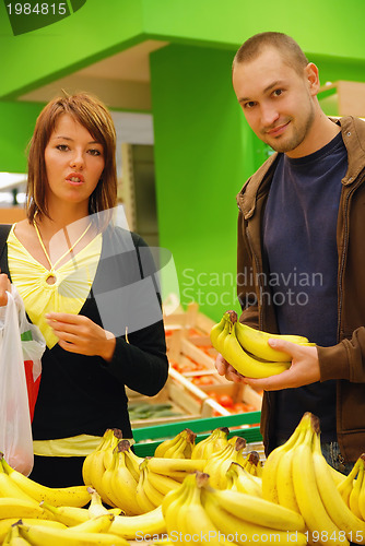 Image of happy couple buying bananas
