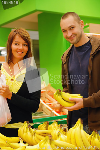 Image of happy couple buying bananas