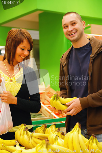 Image of happy couple buying bananas