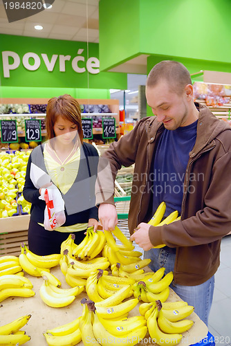 Image of happy couple buying bananas