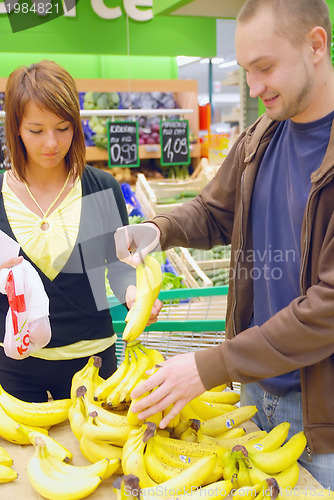 Image of happy couple buying bananas