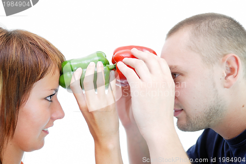 Image of happy couple holding peppers with head