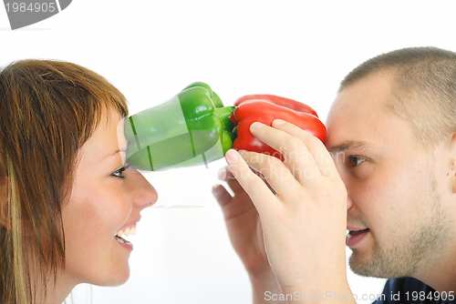 Image of happy couple holding peppers with head