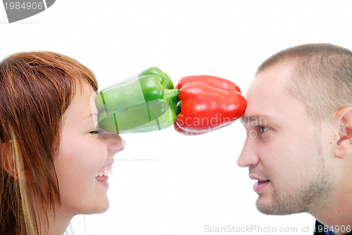 Image of happy couple holding peppers with head