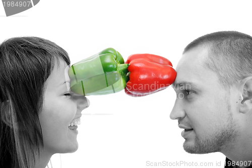 Image of happy couple holding peppers with head