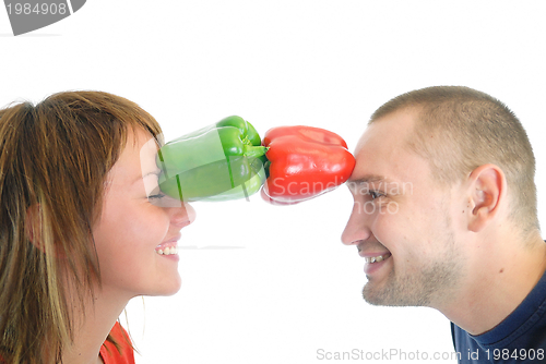 Image of happy couple holding peppers with head