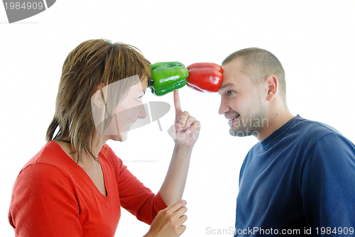 Image of happy couple holding peppers with head