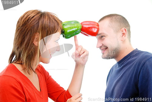 Image of happy couple holding peppers with head