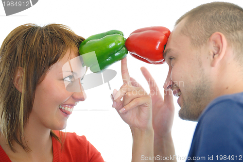 Image of happy couple holding peppers with head