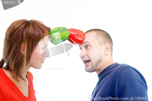 Image of happy couple holding peppers with head